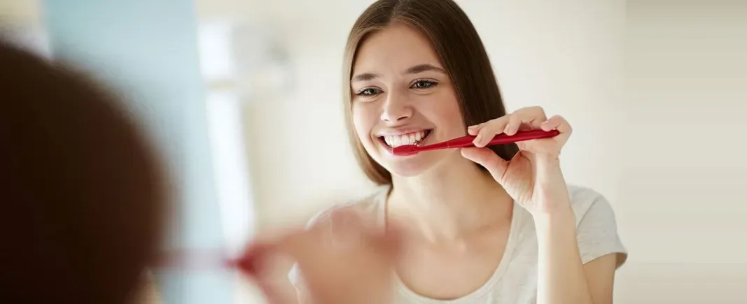 Woman brushing her teeth and smiling